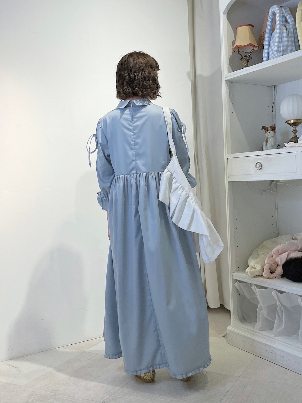 ホワイト系のトートバッグ、ブルー系のワンピース、ゴールド系のパンプスを着用したレディースの春コーディネートの3枚目の写真