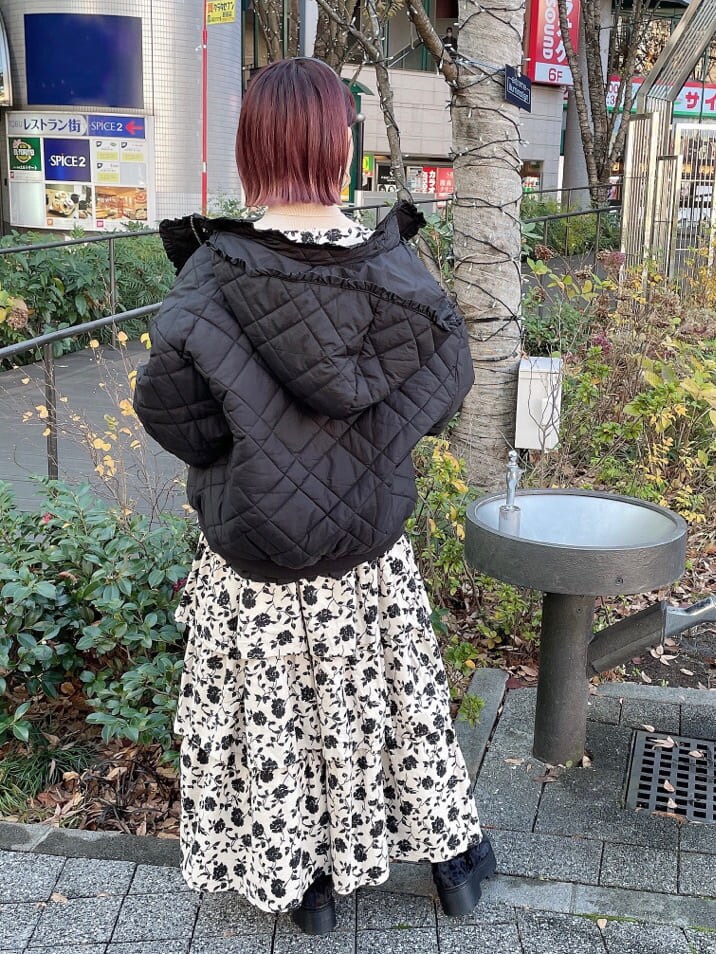 ブラック系のブーツ、ブラック系のナイロンジャケット、ホワイト系のジャンパースカートを着用したレディースの冬コーディネートの3枚目の写真