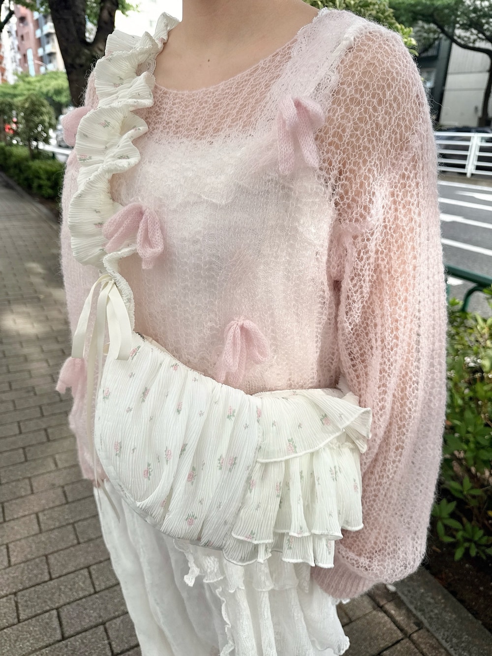 ピンク系のニット/セーター、ホワイト系のショルダーバッグ、ホワイト系のワンピースを着用したレディースの夏コーディネートの4枚目の写真