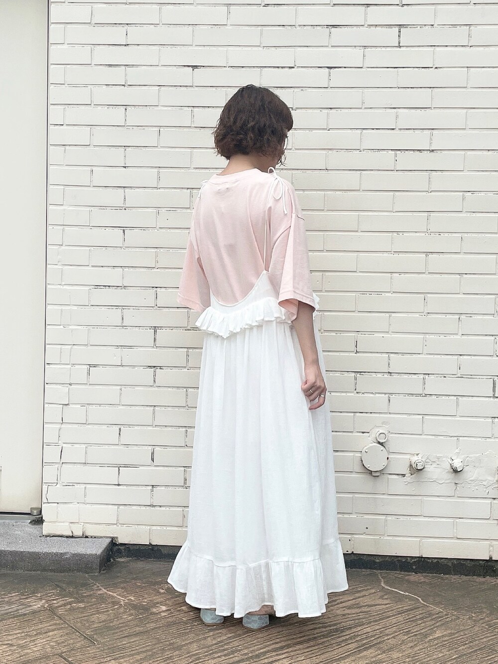 ホワイト系のスカート、ピンク系のTシャツ/カットソー、ピンク系のパンプスを着用したレディースの夏コーディネートの3枚目の写真