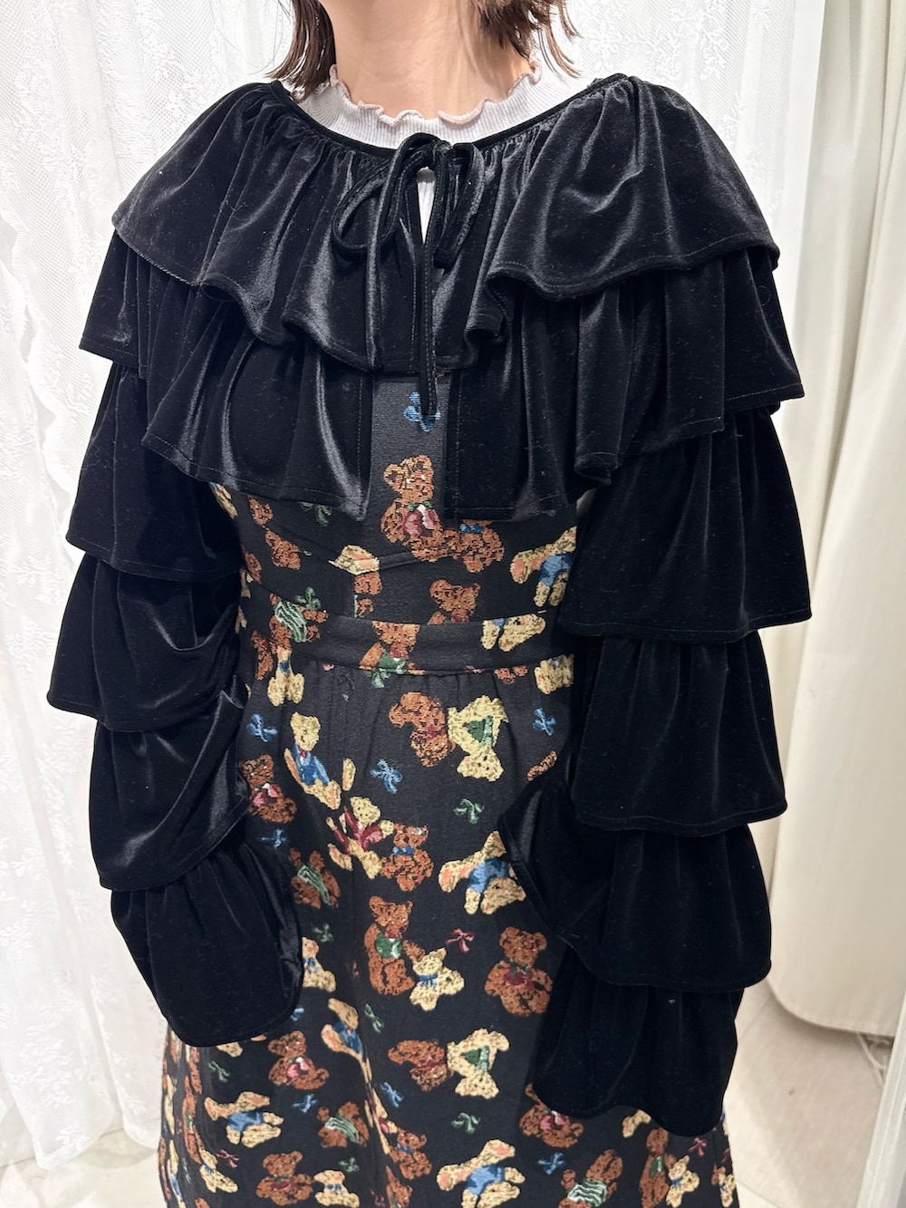 グレー系のニット/セーター、ブラック系のカーディガン/ボレロ、ブラック系のジャンパースカートを着用したレディースの秋コーディネートの6枚目の写真