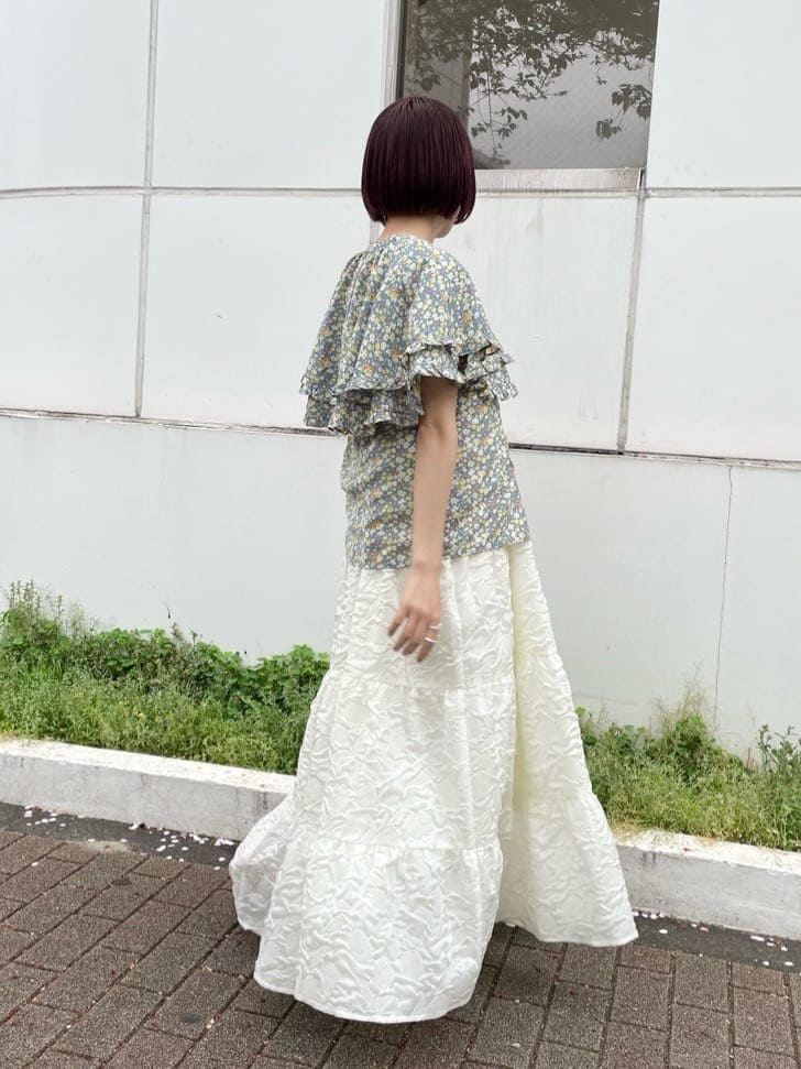 ホワイト系のワンピース、イエロー系のシャツ/ブラウス、オレンジ系のパンプスを着用したレディースの春コーディネートの3枚目の写真