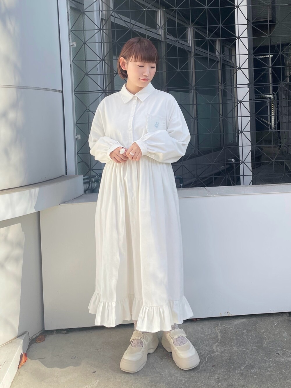 ホワイト系のダウンジャケット/コート、ホワイト系のワンピース、ホワイト系のスニーカーを着用したレディースの冬コーディネートの7枚目の写真