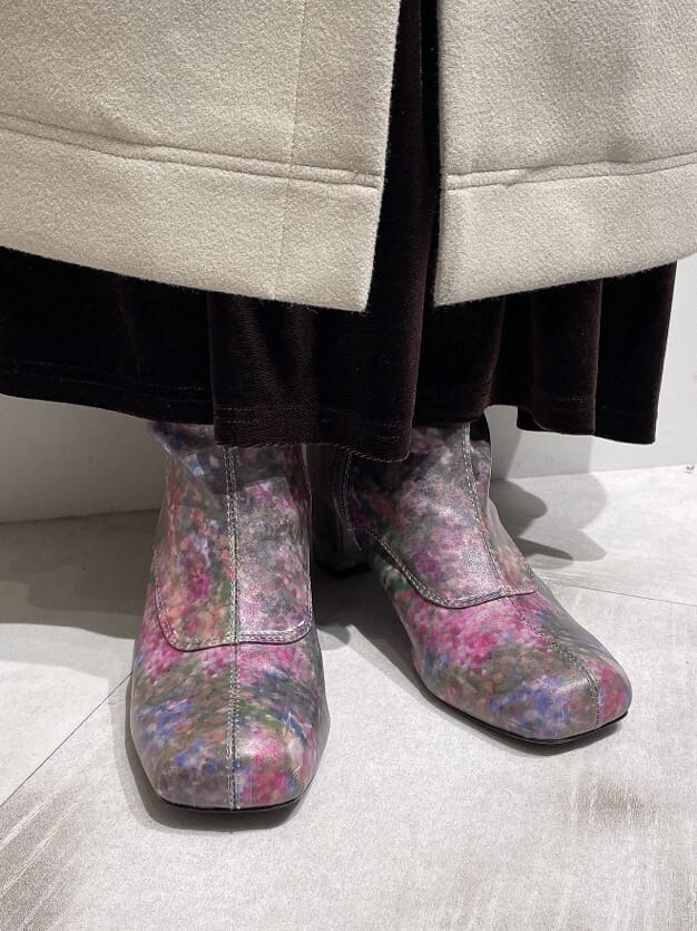 ブラウン系のスカート、ピンク系のニット/セーター、ピンク系のブーツを着用したレディースの秋コーディネートの5枚目の写真