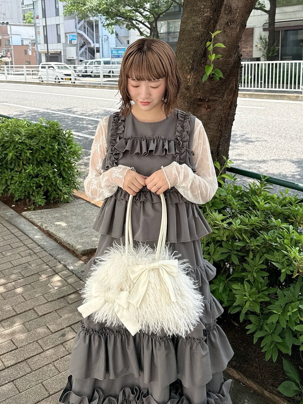 グレー系のワンピース、ホワイト系のTシャツ/カットソー、ホワイト系のボストンバッグを着用したレディースの春コーディネートの4枚目の写真