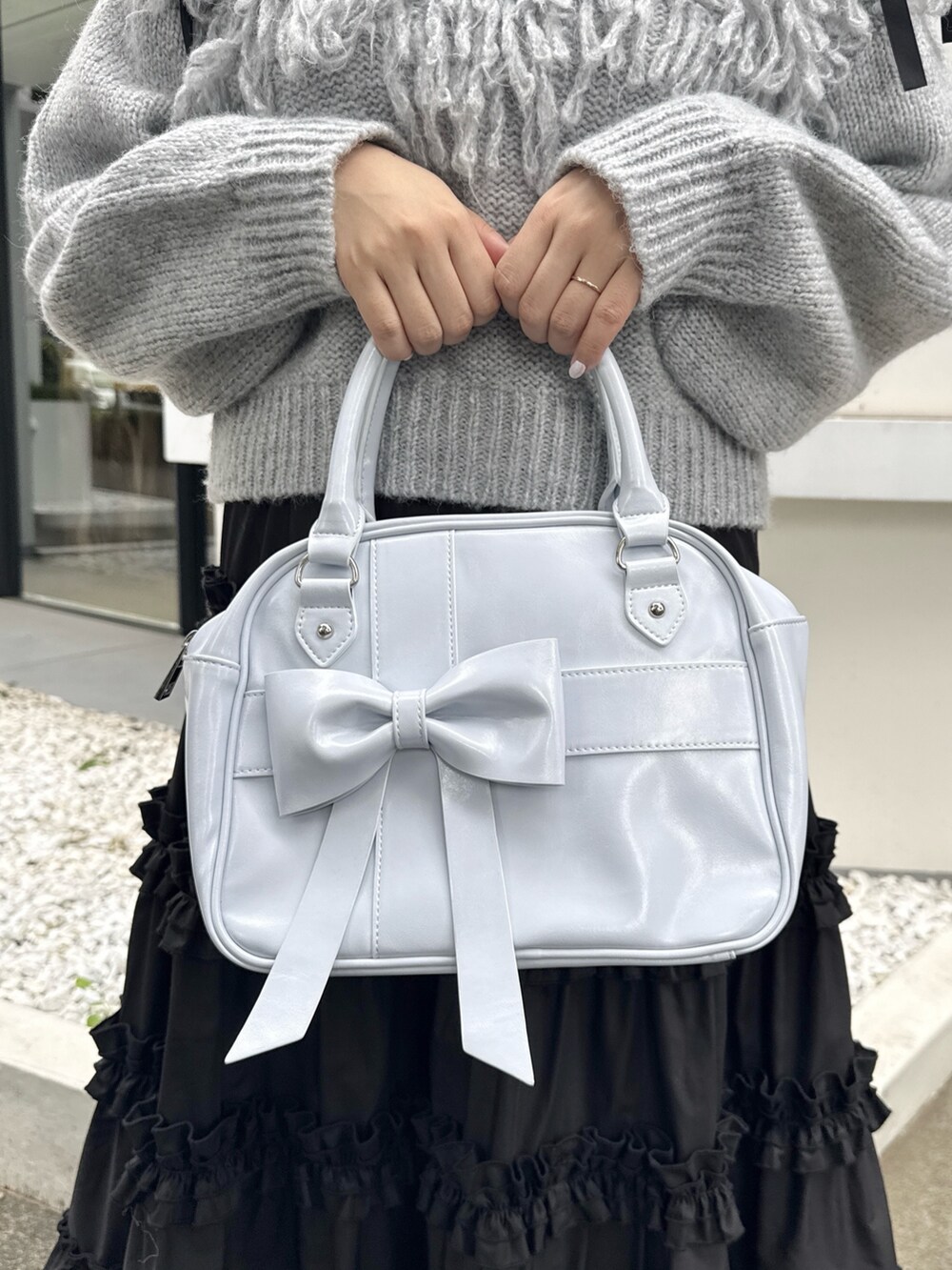 グレー系のニット/セーター、ブラック系のスカート、ブラック系のスニーカーを着用したレディースの夏コーディネートの8枚目の写真