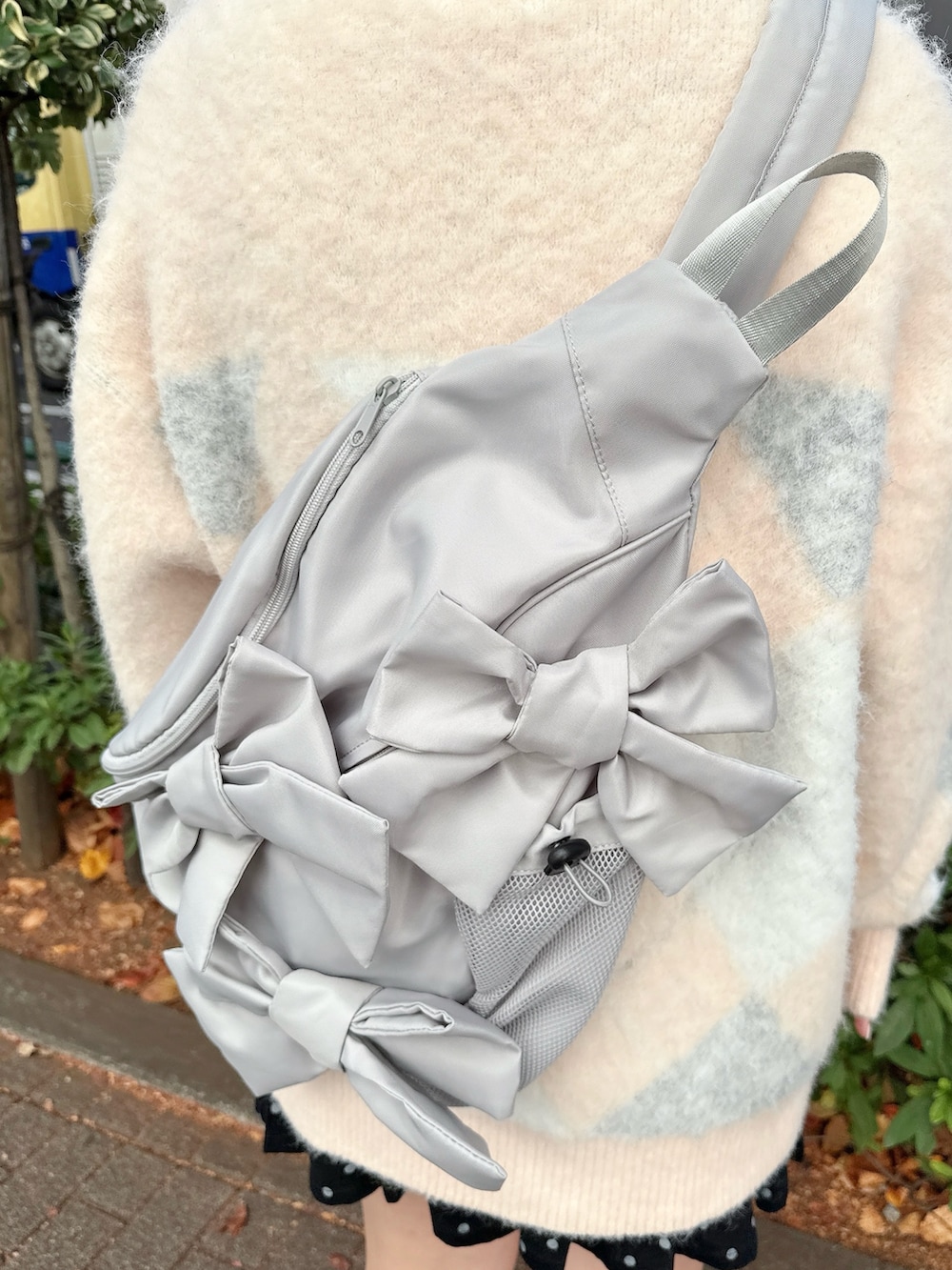 ピンク系のニット/セーター、グレー系のショルダーバッグ、ブラック系のスカートを着用したレディースの冬コーディネートの6枚目の写真