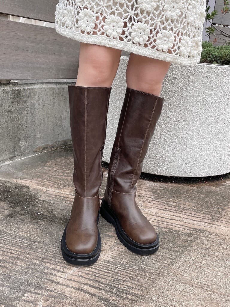 ホワイト系のニット/セーター、ホワイト系のその他パンツ、ブラウン系のブーツを着用したレディースの秋コーディネートの4枚目の写真