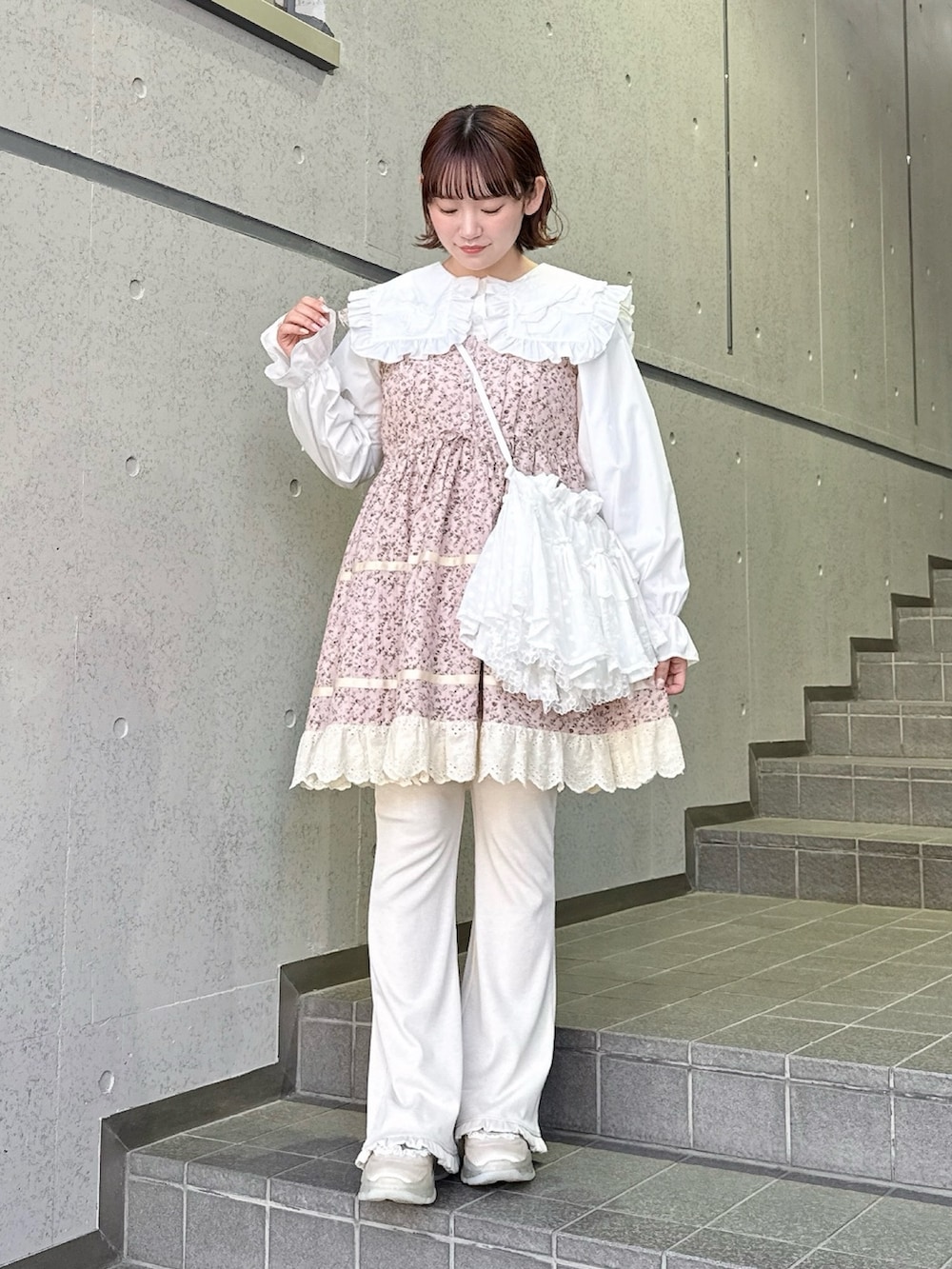 ホワイト系のシャツ/ブラウス、ホワイト系のショルダーバッグ、ホワイト系のスニーカーを着用したレディースの冬コーディネートの2枚目の写真