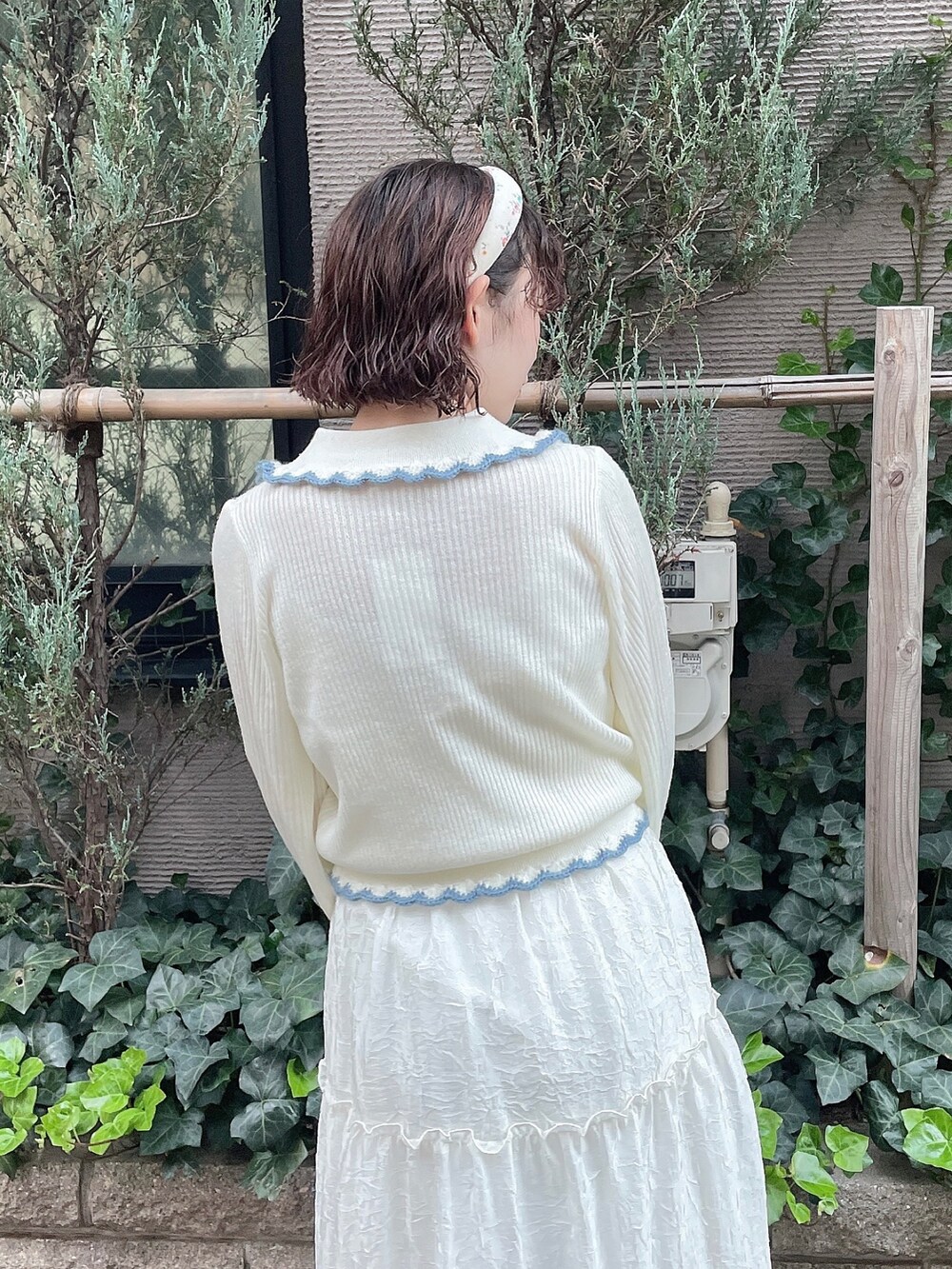 ホワイト系のニット/セーター、ホワイト系のワンピース、ホワイト系のパンプスを着用したレディースの秋コーディネートの4枚目の写真