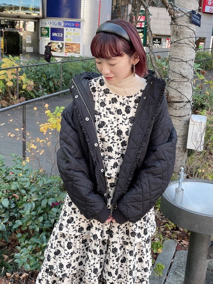 ブラック系のブーツ、ブラック系のナイロンジャケット、ホワイト系のジャンパースカートを着用したレディースの冬コーディネートの4枚目の写真