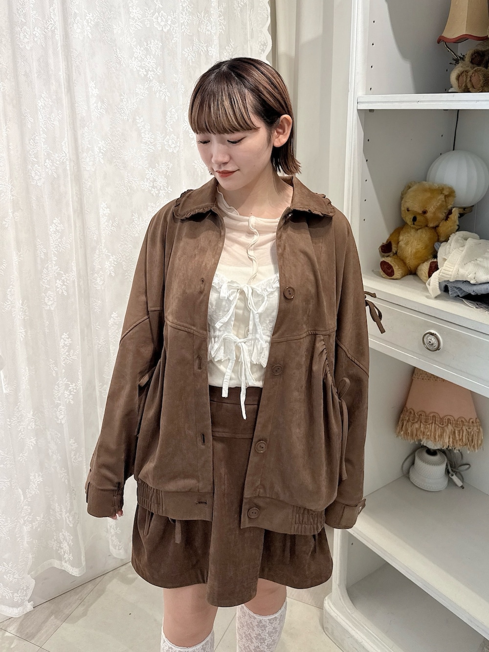 ブラウン系のスカート、ホワイト系のTシャツ/カットソー、ブラウン系のライダースジャケットを着用したレディースの夏コーディネートの4枚目の写真