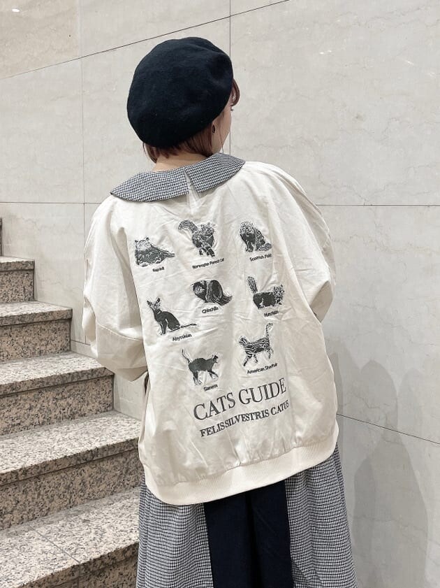 ホワイト系のブーツ、ホワイト系のブルゾン、ブラック系のワンピースを着用したレディースの冬コーディネートの3枚目の写真