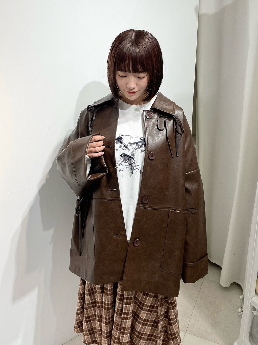 ブラウン系のスカート、ホワイト系のスウェット、ブラウン系のブルゾンを着用したレディースの秋コーディネートの4枚目の写真