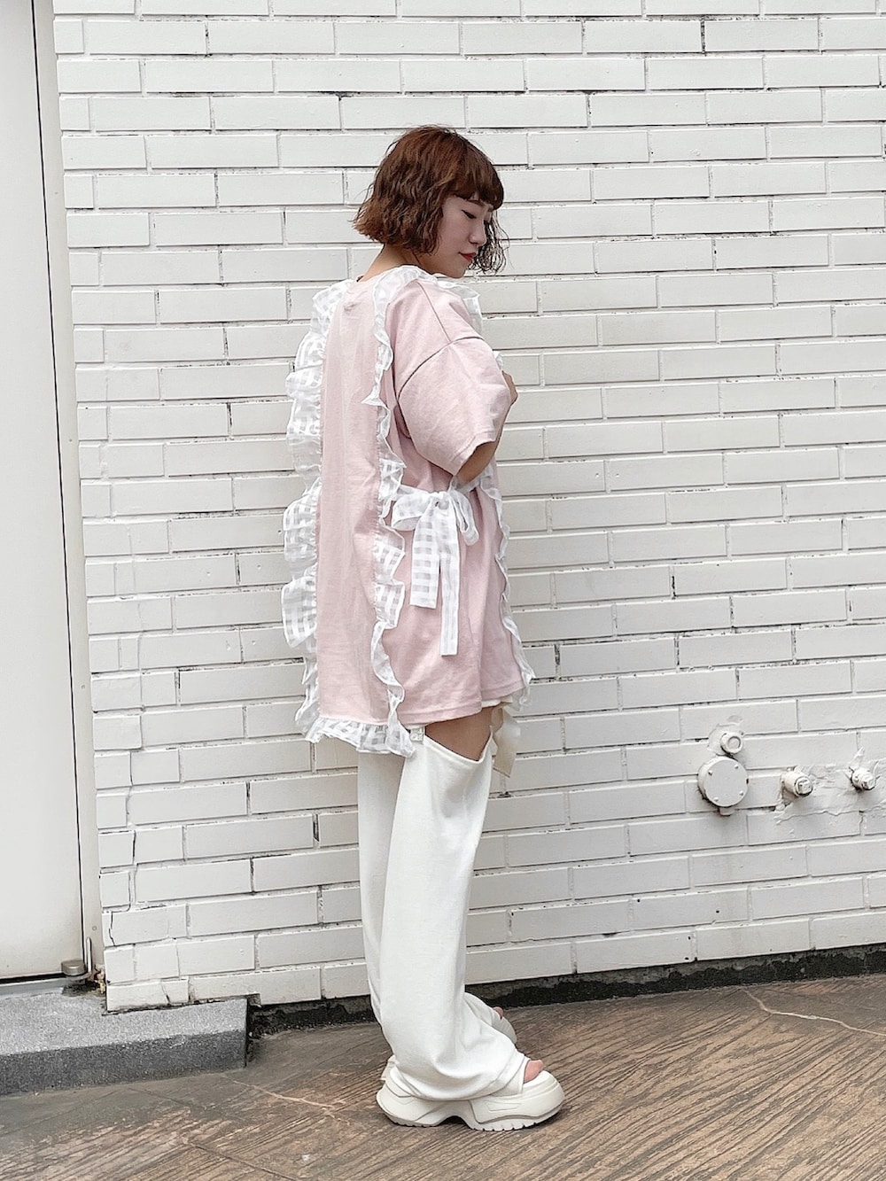 ピンク系のTシャツ/カットソー、ホワイト系のその他パンツ、ホワイト系のサンダルを着用したレディースの春コーディネートの2枚目の写真
