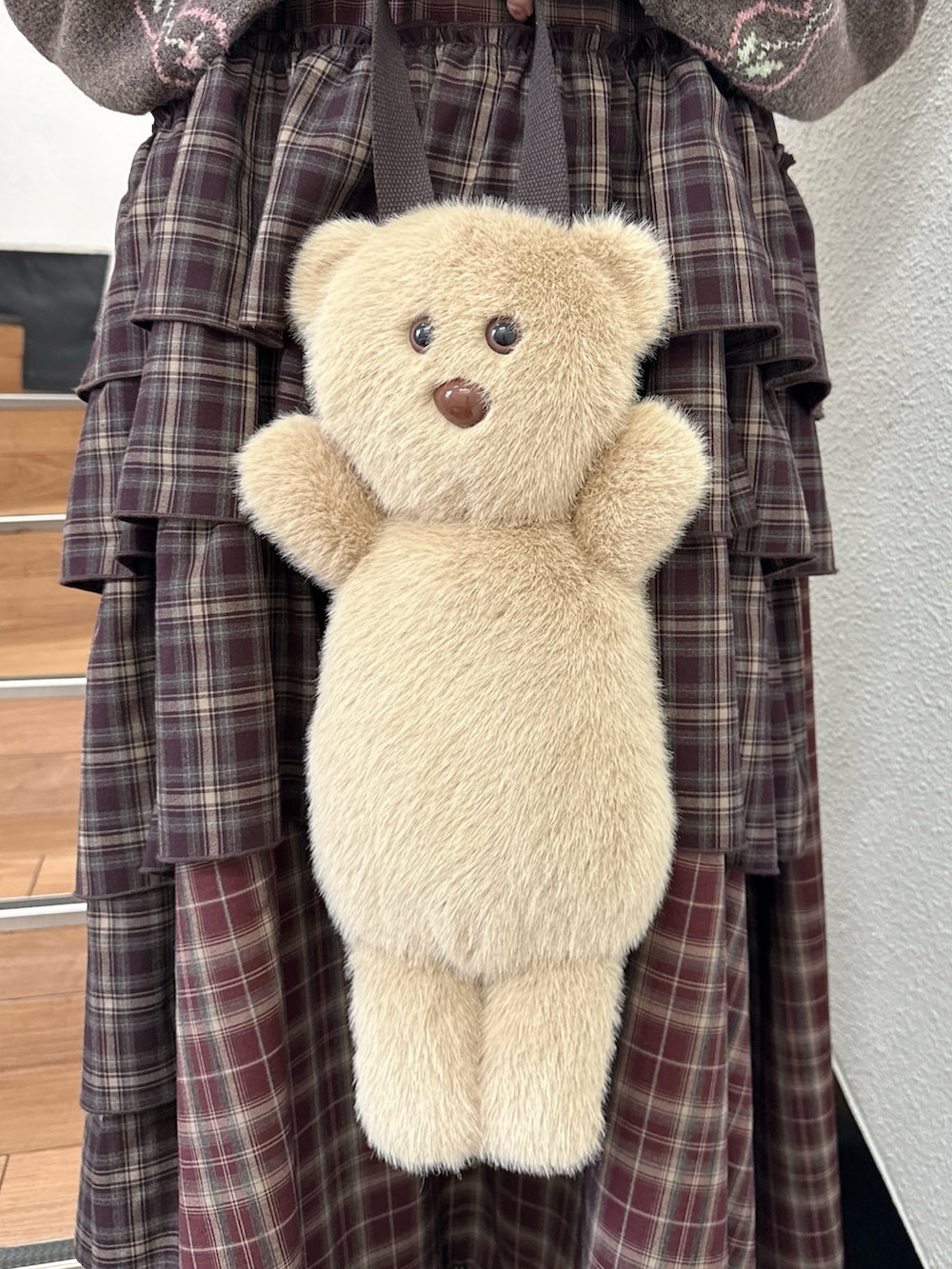 ブラウン系のニット/セーター、レッド系のワンピース、ベージュ系のハンドバッグを着用したレディースの秋コーディネートの6枚目の写真