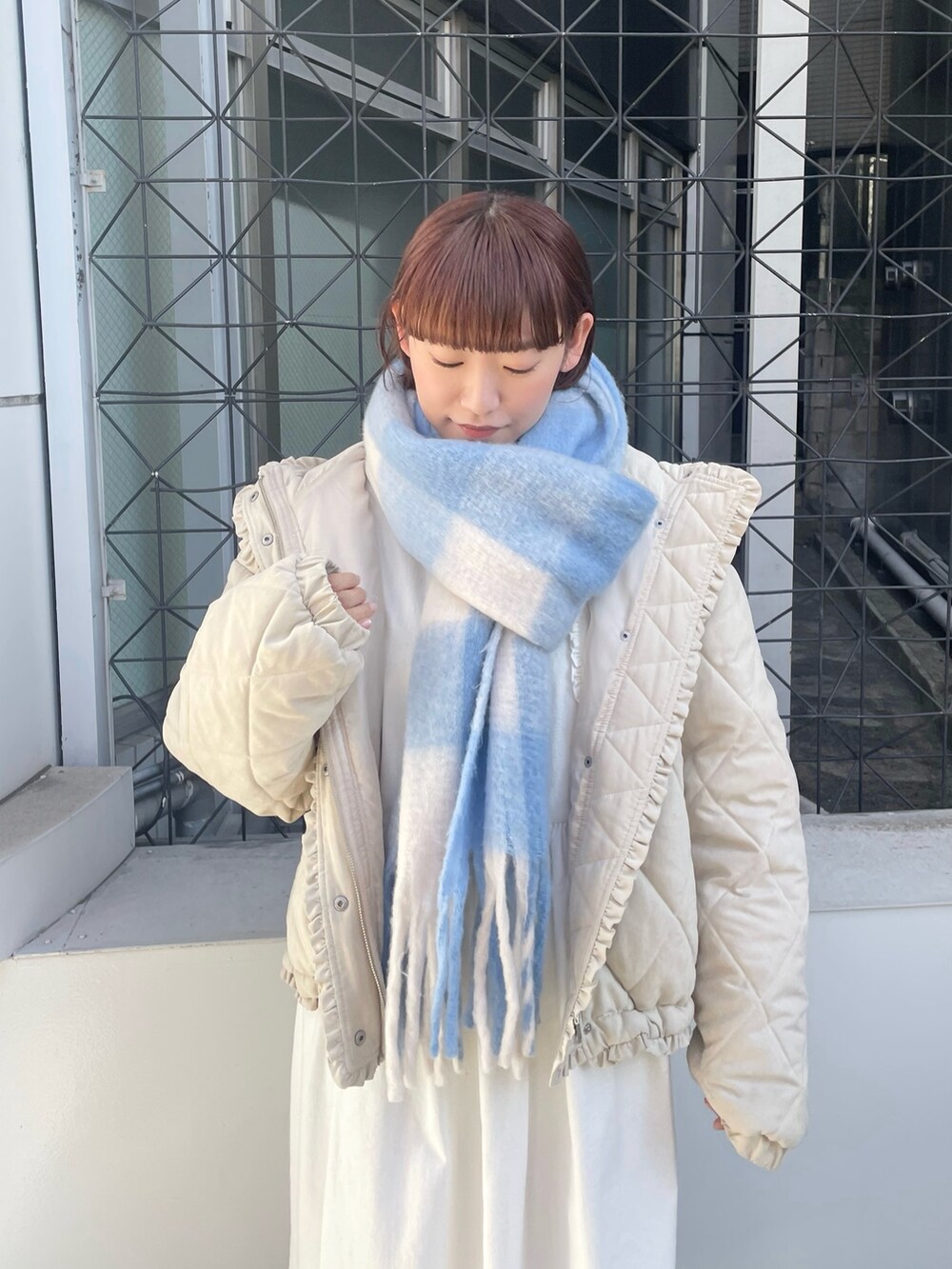 ホワイト系のダウンジャケット/コート、ホワイト系のワンピース、ホワイト系のスニーカーを着用したレディースの冬コーディネートの4枚目の写真