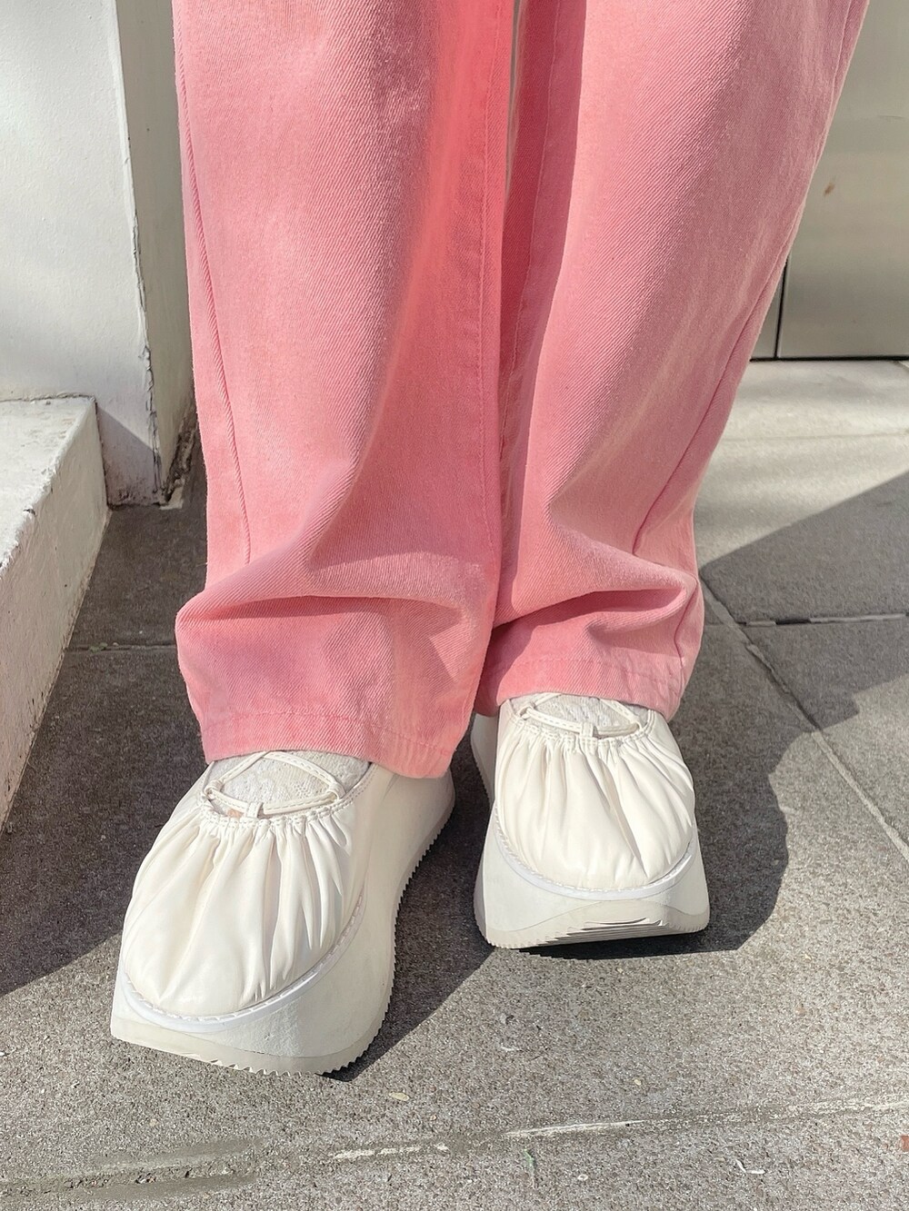 ホワイト系のスウェット、ピンク系のデニムパンツ、ホワイト系のショルダーバッグを着用したレディースの冬コーディネートの8枚目の写真