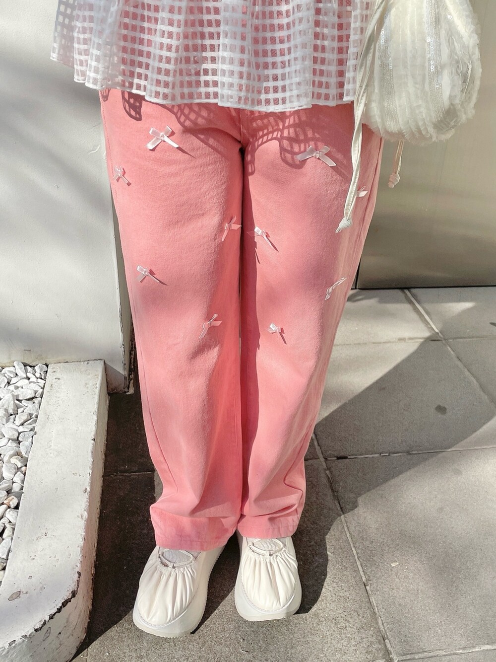 ホワイト系のスウェット、ピンク系のデニムパンツ、ホワイト系のショルダーバッグを着用したレディースの冬コーディネートの7枚目の写真