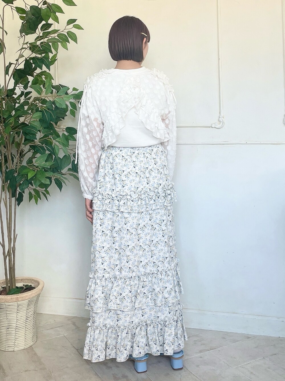イエロー系のスカート、ブルー系のサンダル、ホワイト系のTシャツ/カットソーを着用したレディースの春コーディネートの3枚目の写真