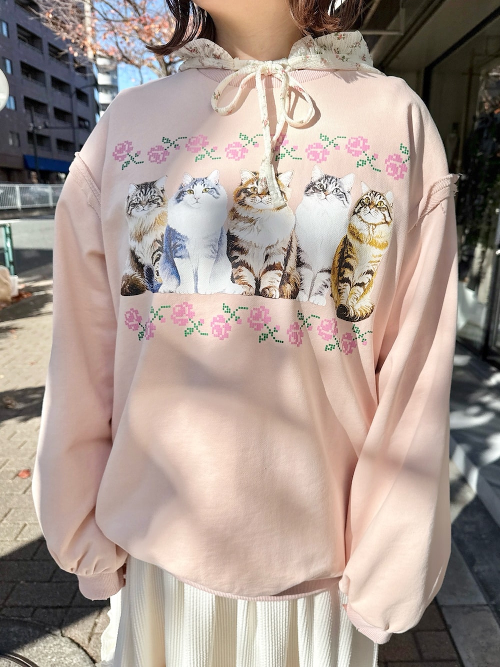 ピンク系のスウェット、ホワイト系のTシャツ/カットソー、ホワイト系のスカートを着用したレディースの冬コーディネートの8枚目の写真