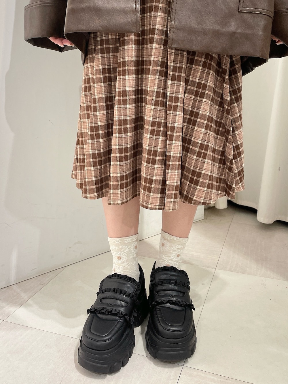 ブラウン系のスカート、ホワイト系のスウェット、ブラウン系のブルゾンを着用したレディースの秋コーディネートの10枚目の写真