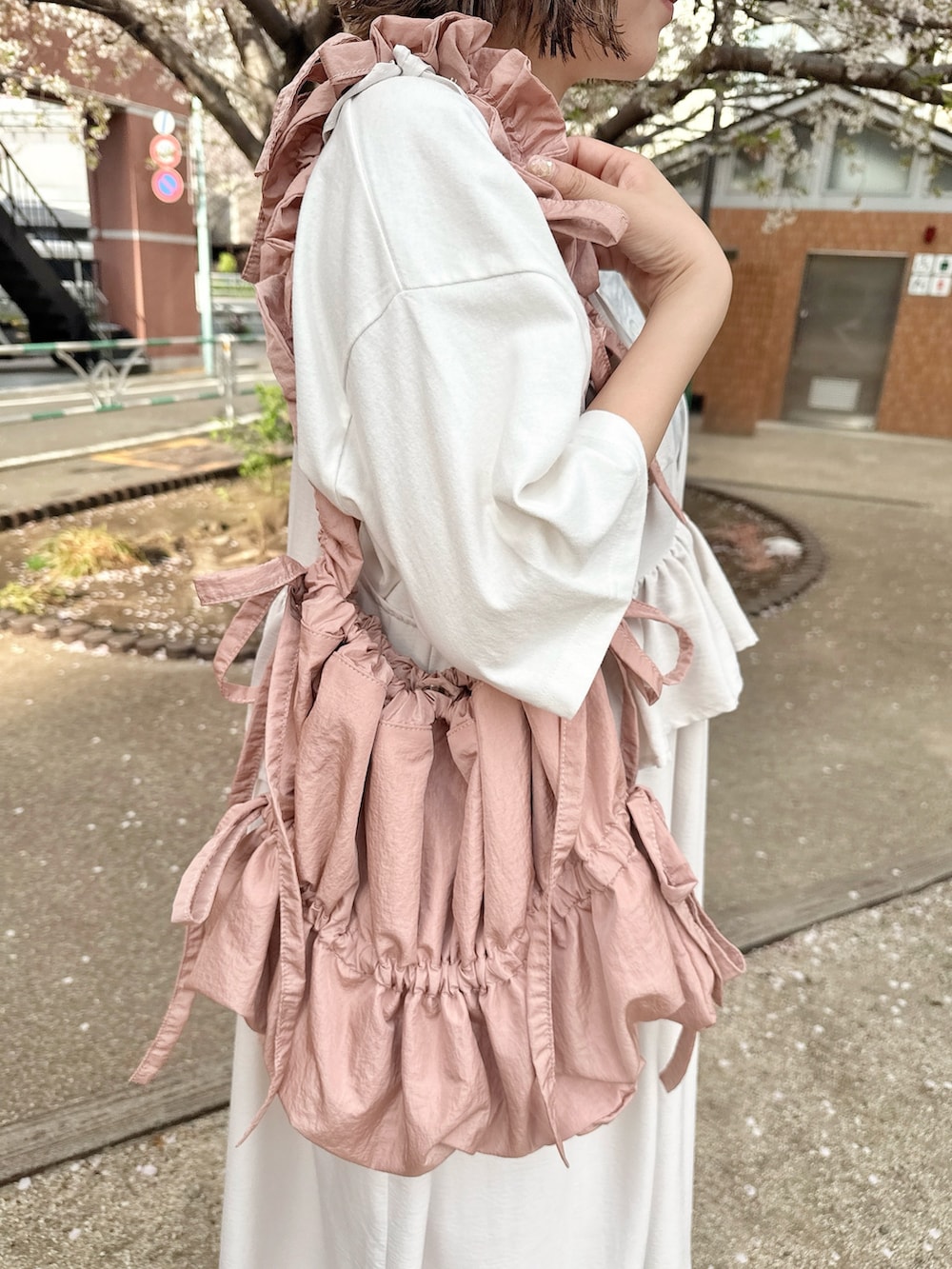 ホワイト系のTシャツ/カットソー、ホワイト系のワンピース、ピンク系のトートバッグを着用したレディースの春コーディネートの7枚目の写真