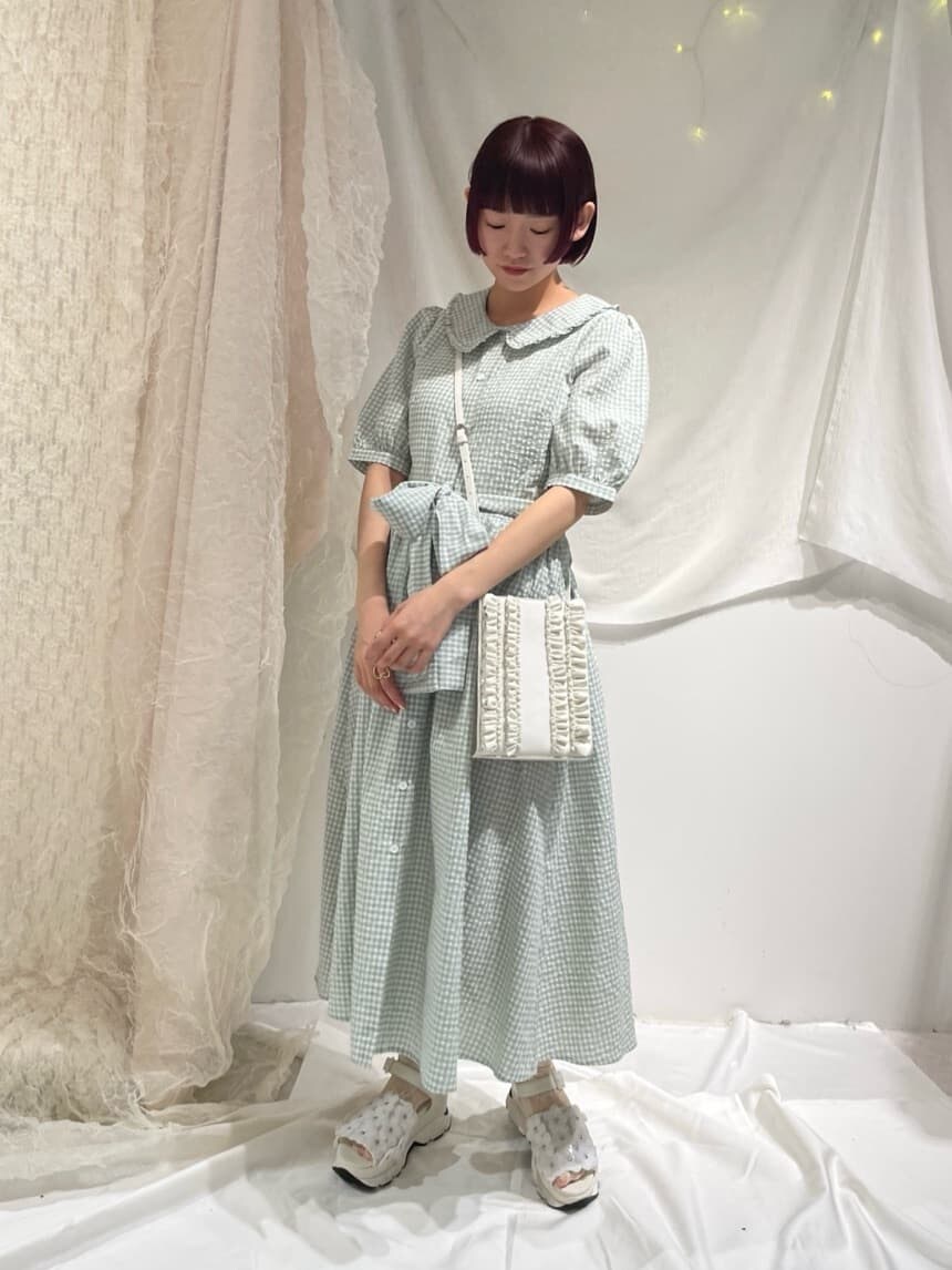 ホワイト系のサンダル、ホワイト系のショルダーバッグ、グリーン系のワンピースを着用したレディースの春コーディネートの2枚目の写真