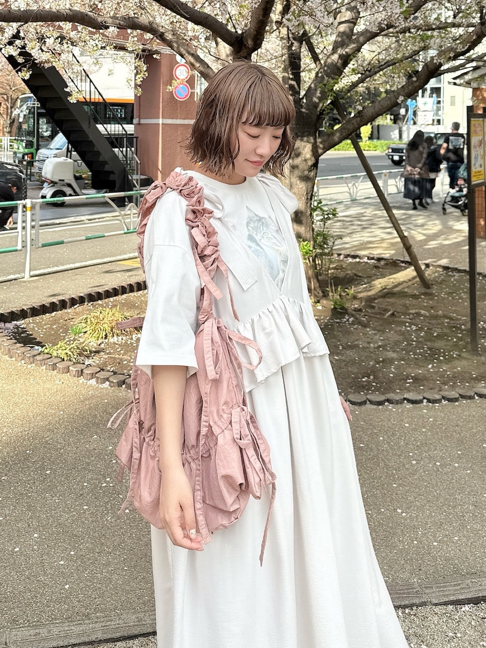 ホワイト系のTシャツ/カットソー、ホワイト系のワンピース、ピンク系のトートバッグを着用したレディースの春コーディネートの5枚目の写真