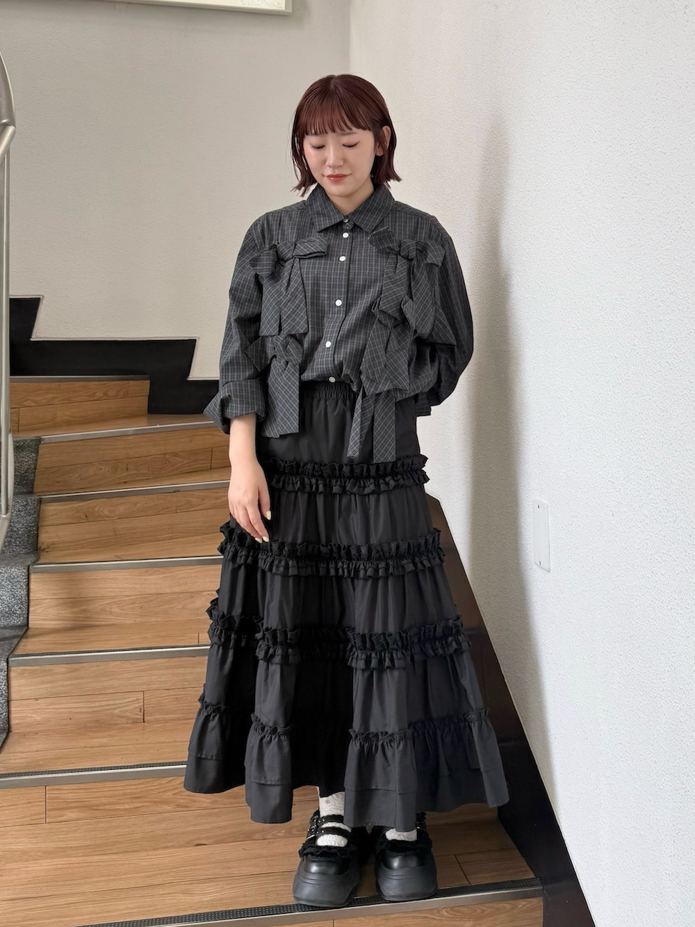 グリーン系のシャツ/ブラウス、ブラック系のスカート、ブラック系のスニーカーを着用したレディースの夏コーディネートの2枚目の写真