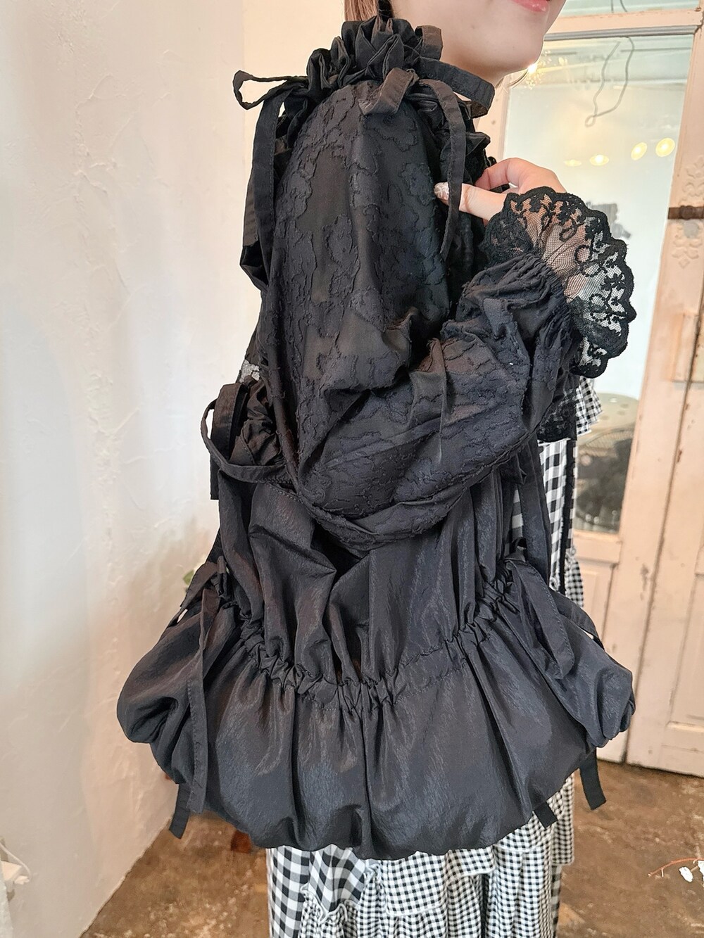ブラック系のニット/セーター、ブラック系のカーディガン/ボレロ、ブラック系のトートバッグを着用したレディースの春コーディネートの5枚目の写真
