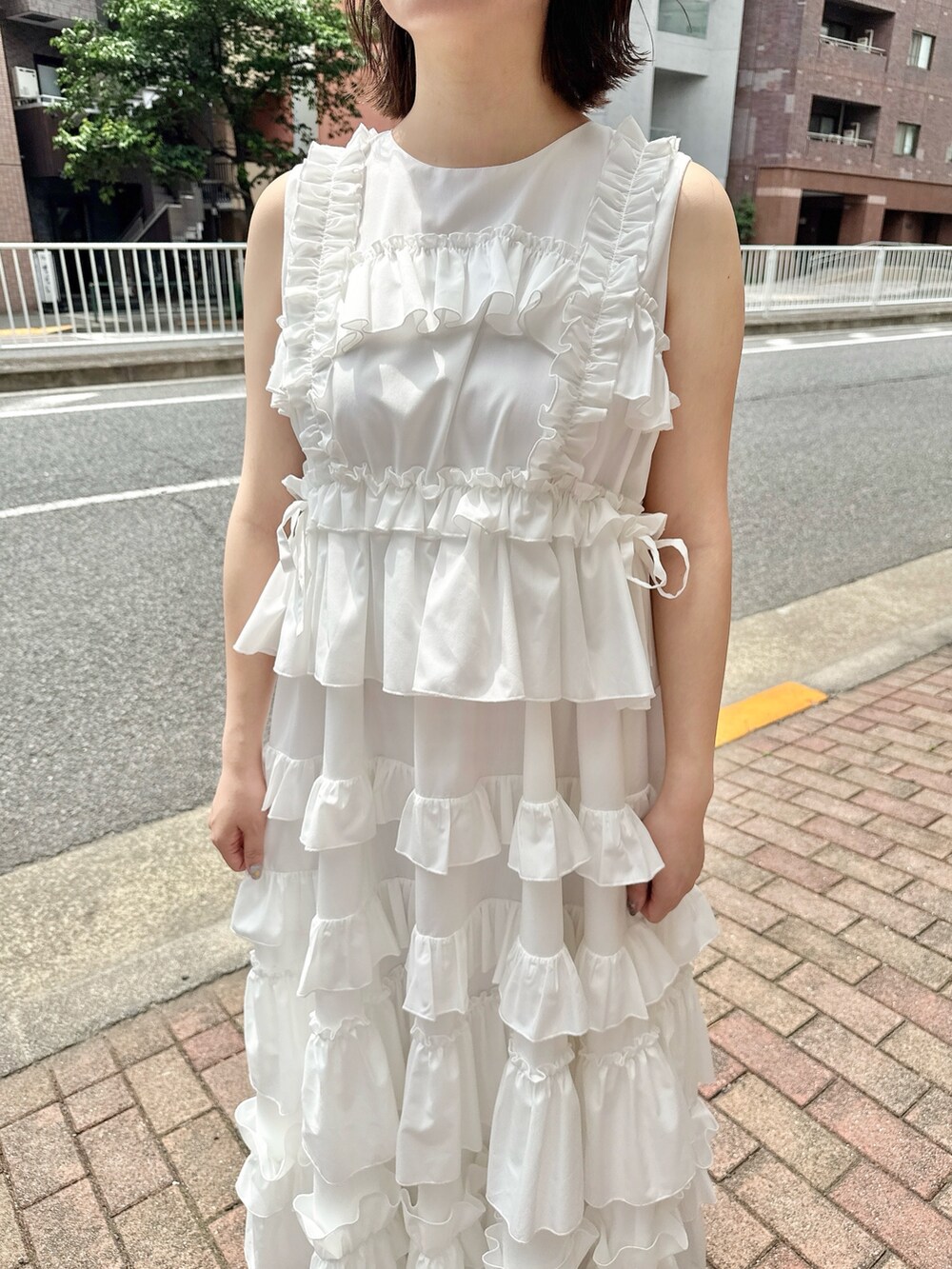 ホワイト系のワンピース、ピンク系のスニーカー、ピンク系の長傘を着用したレディースの春コーディネートの6枚目の写真