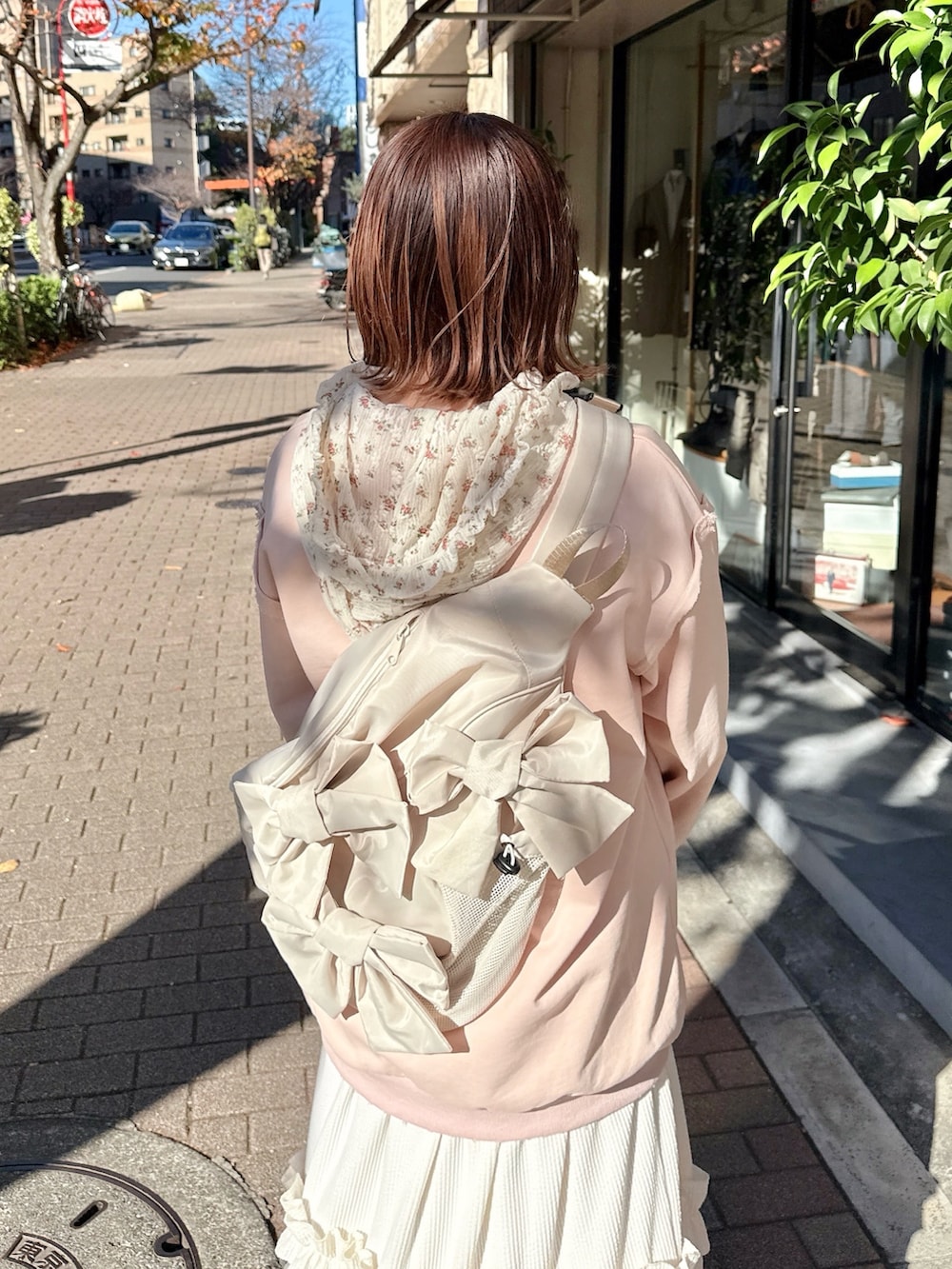 ピンク系のスウェット、ホワイト系のTシャツ/カットソー、ホワイト系のスカートを着用したレディースの冬コーディネートの4枚目の写真