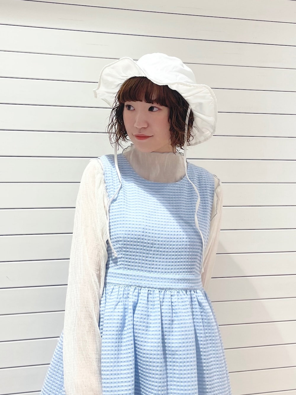 ブルー系のワンピース、ホワイト系のTシャツ/カットソー、ブルー系のサンダルを着用したレディースの夏コーディネートの4枚目の写真