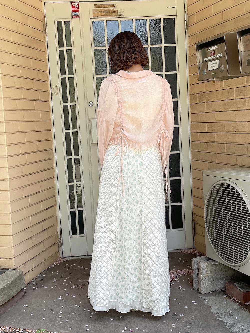 グリーン系のワンピース、ピンク系のシャツ/ブラウス、ホワイト系のTシャツ/カットソーを着用したレディースの春コーディネートの3枚目の写真