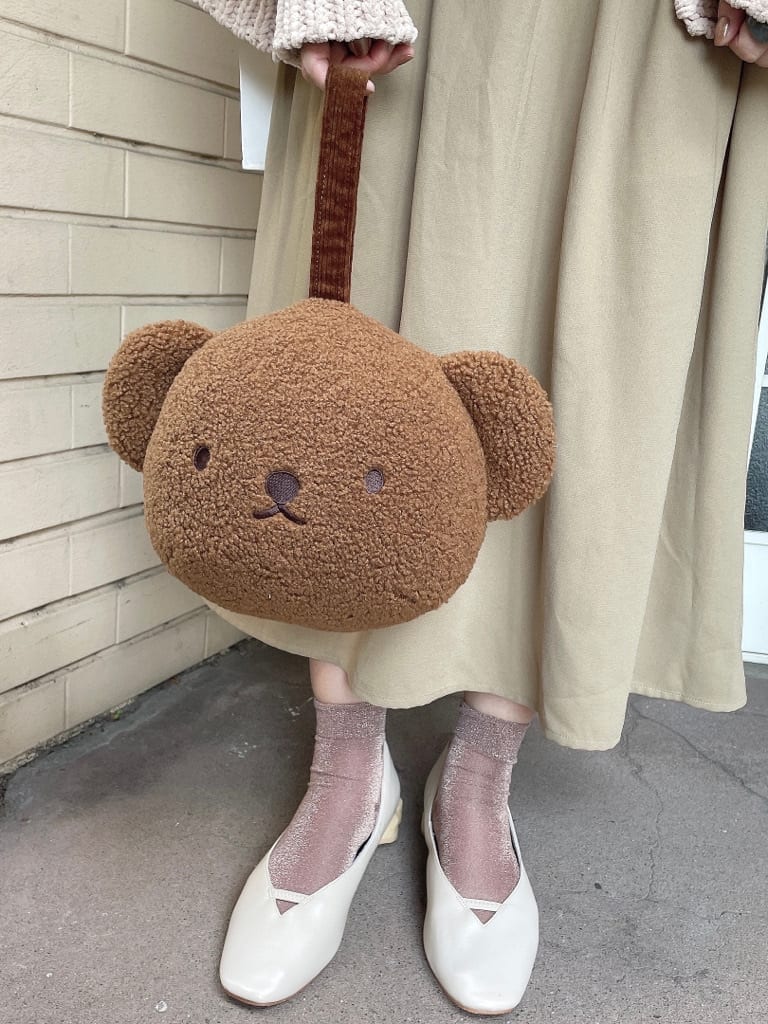 ベージュ系のワンピース、ブラウン系のハンドバッグ、ホワイト系のパンプスを着用したレディースの秋コーディネートの5枚目の写真