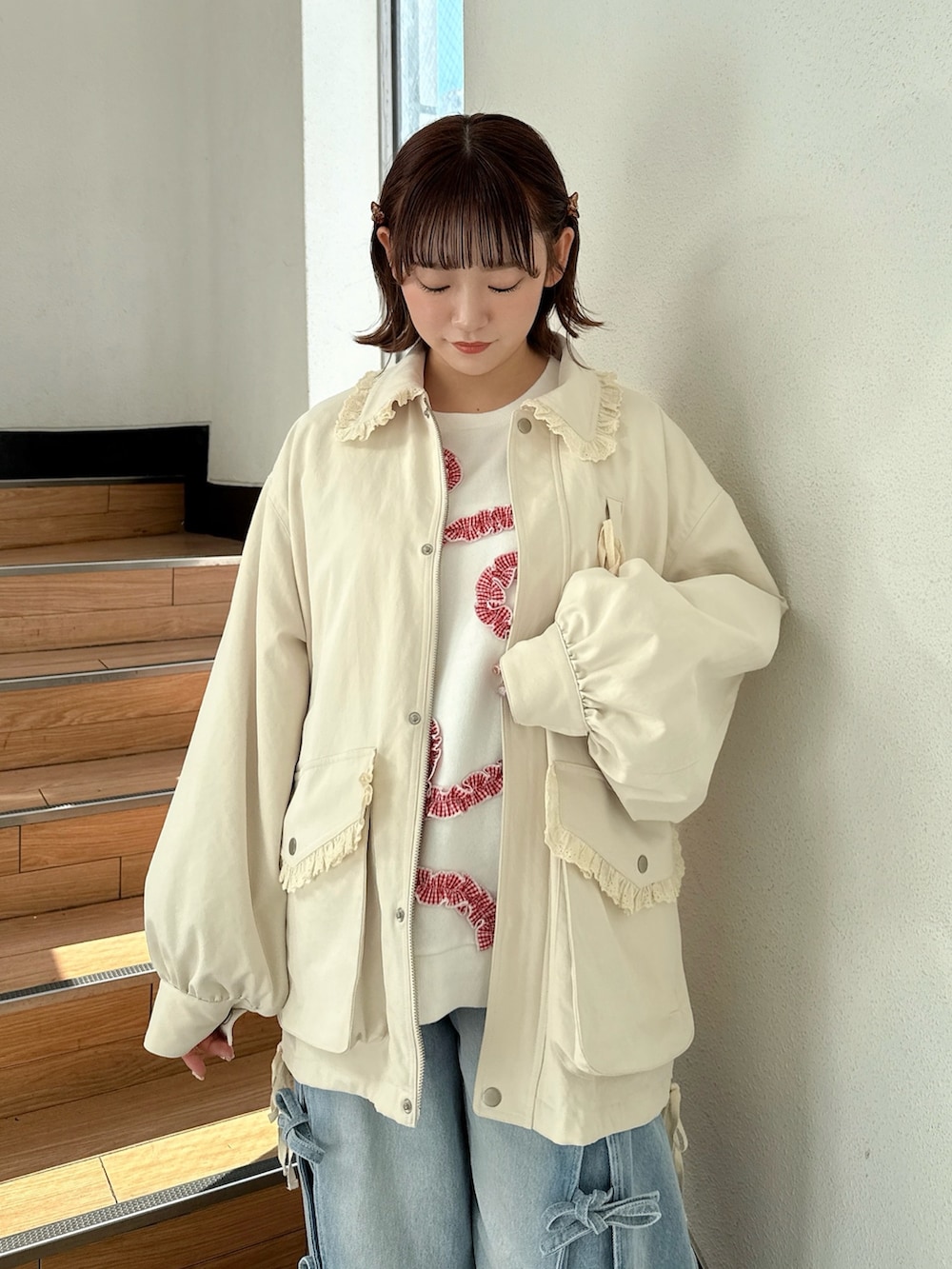 ホワイト系のブルゾン、ホワイト系のスウェット、ブルー系のデニムパンツを着用したレディースの冬コーディネートの4枚目の写真