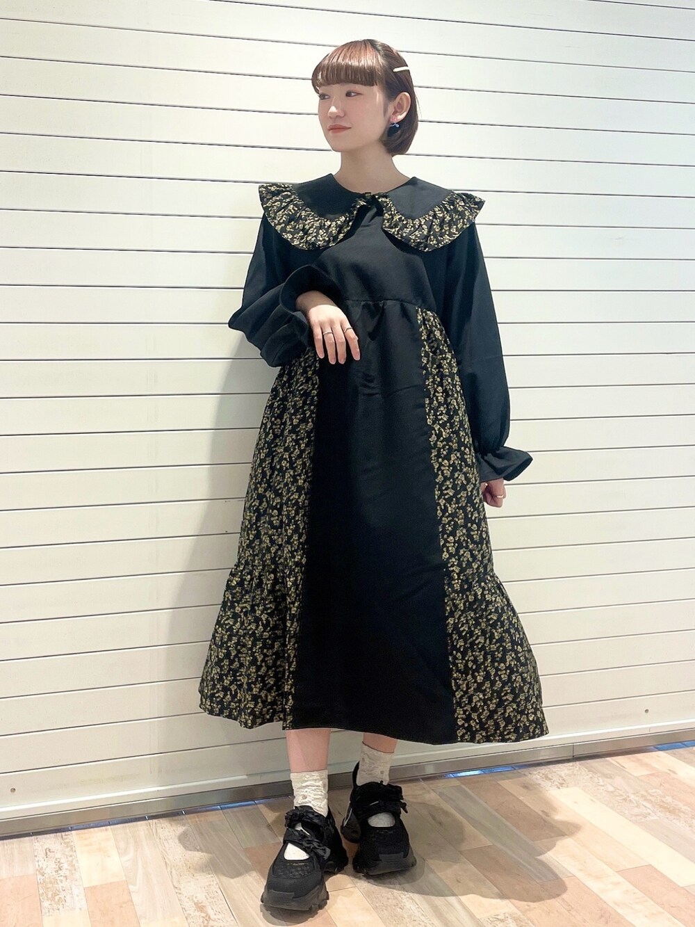 ブラック系のワンピース、ブラック系のスニーカーを着用したレディースの冬コーディネートの2枚目の写真