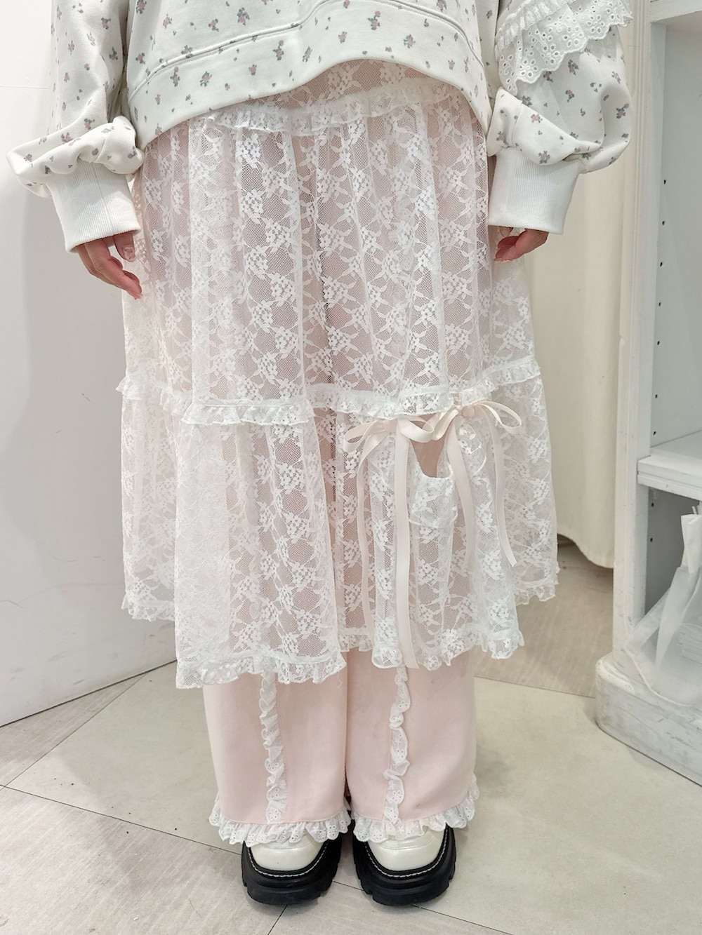 ホワイト系のスウェット、ホワイト系のスカート、ホワイト系のローファーを着用したレディースの冬コーディネートの6枚目の写真