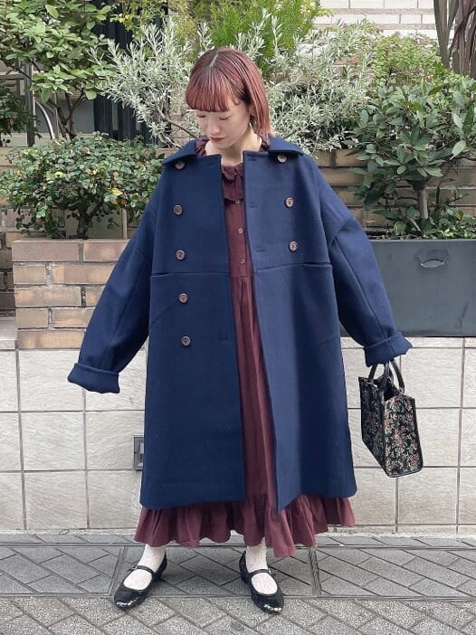 ブルー系のチェスターコート、レッド系のワンピース、その他のパンプスを着用したレディースの秋コーディネートの2枚目の写真