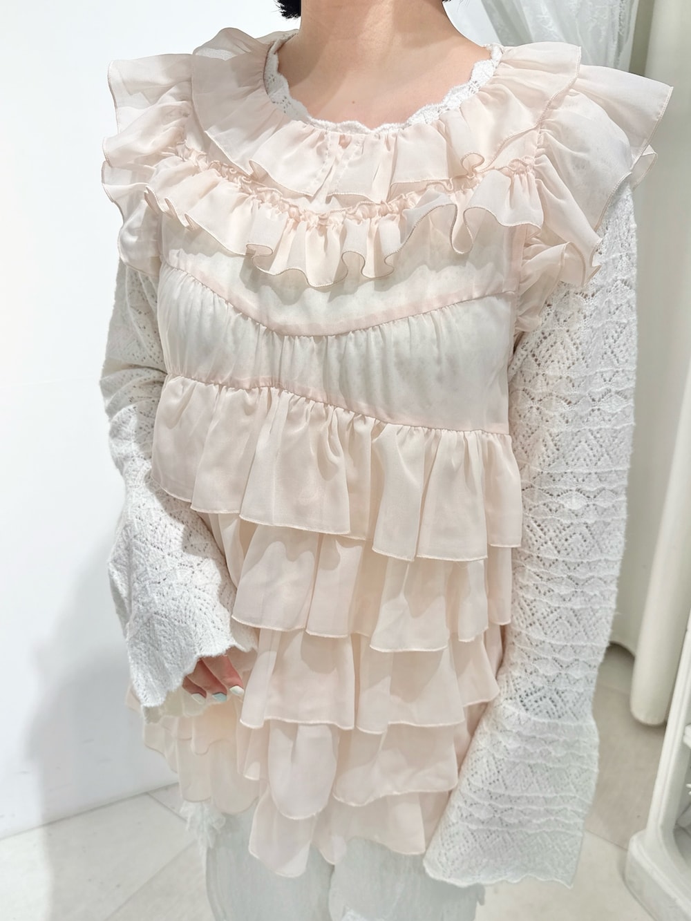 ピンク系のシャツ/ブラウス、ホワイト系のニット/セーター、ピンク系のハンドバッグを着用したレディースの夏コーディネートの6枚目の写真