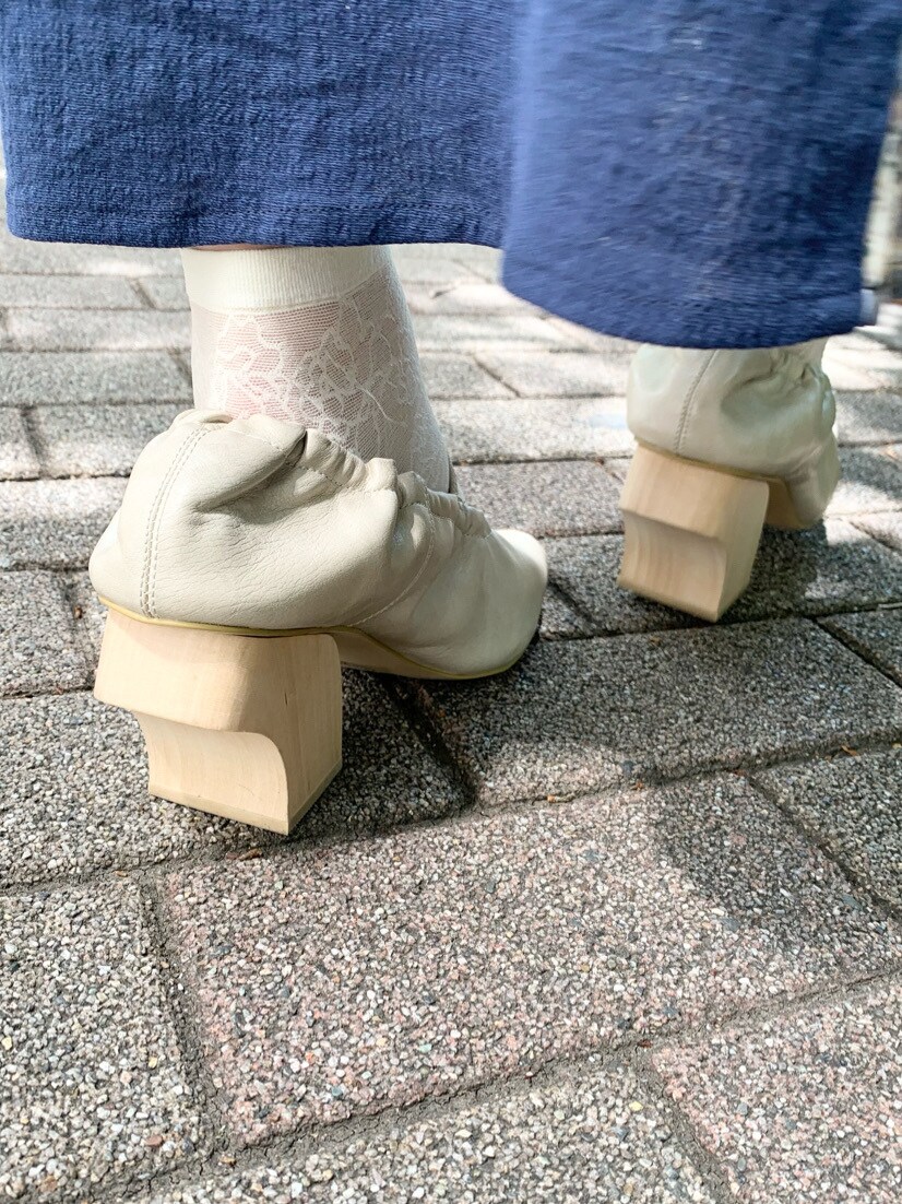 ホワイト系のパンプス、ベージュ系のシャツ/ブラウス、ブルー系のスカートを着用したレディースの春コーディネートの8枚目の写真