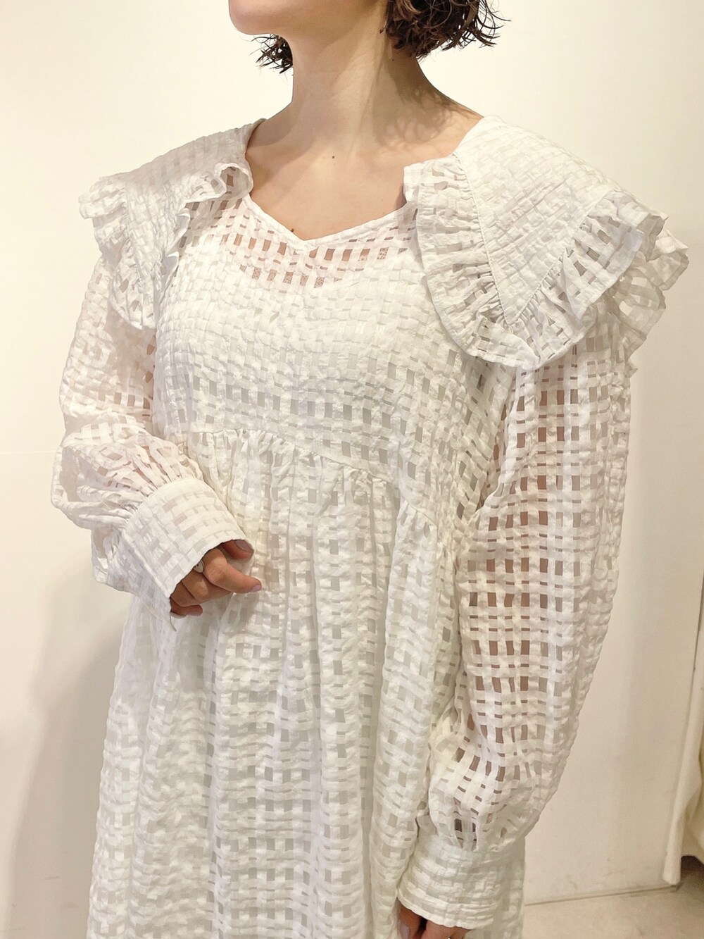 ホワイト系のワンピース、ホワイト系のサンダル、パープル系のキャップを着用したレディースの春コーディネートの5枚目の写真