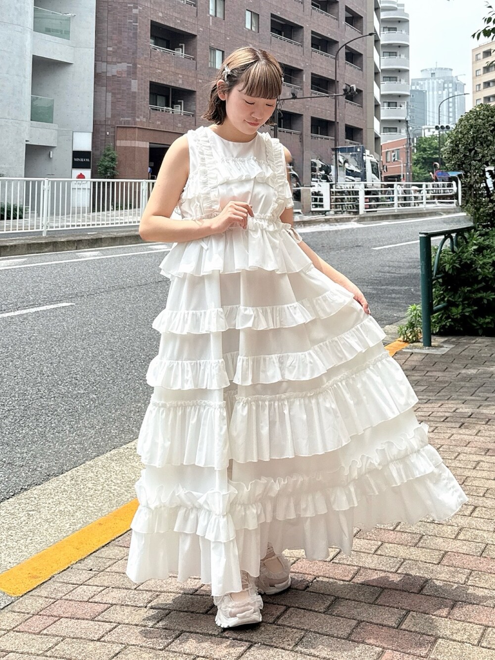 ホワイト系のワンピース、ピンク系のスニーカー、ピンク系の長傘を着用したレディースの春コーディネートの3枚目の写真