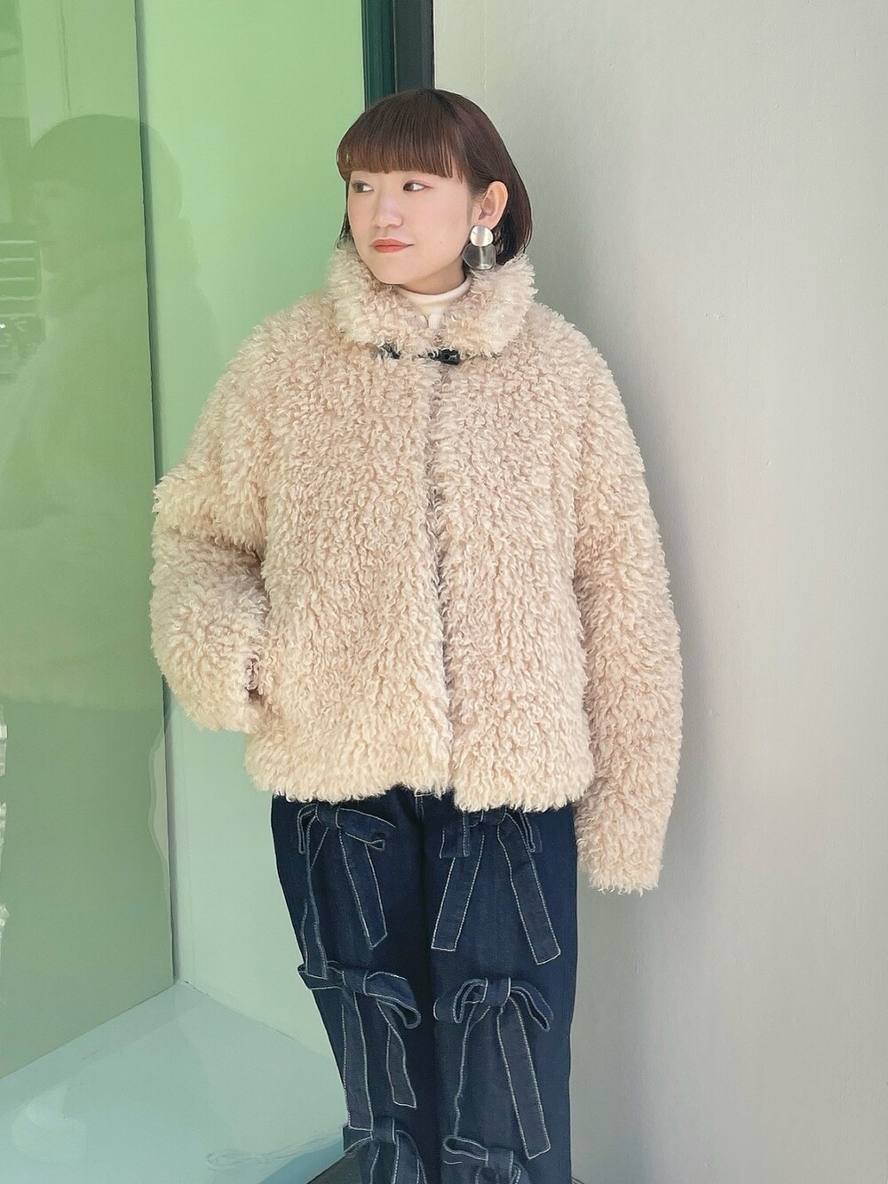 ホワイト系のダウンジャケット/コート、ブルー系のデニムパンツ、ホワイト系のスニーカーを着用したレディースの冬コーディネートの4枚目の写真