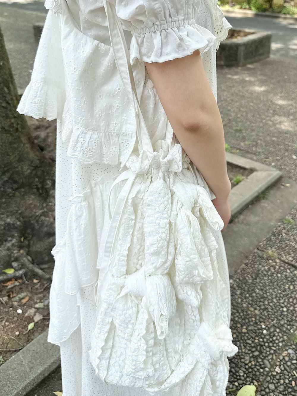 ホワイト系のシャツ/ブラウス、ホワイト系のサンダル、ホワイト系のトートバッグを着用したレディースの春コーディネートの8枚目の写真