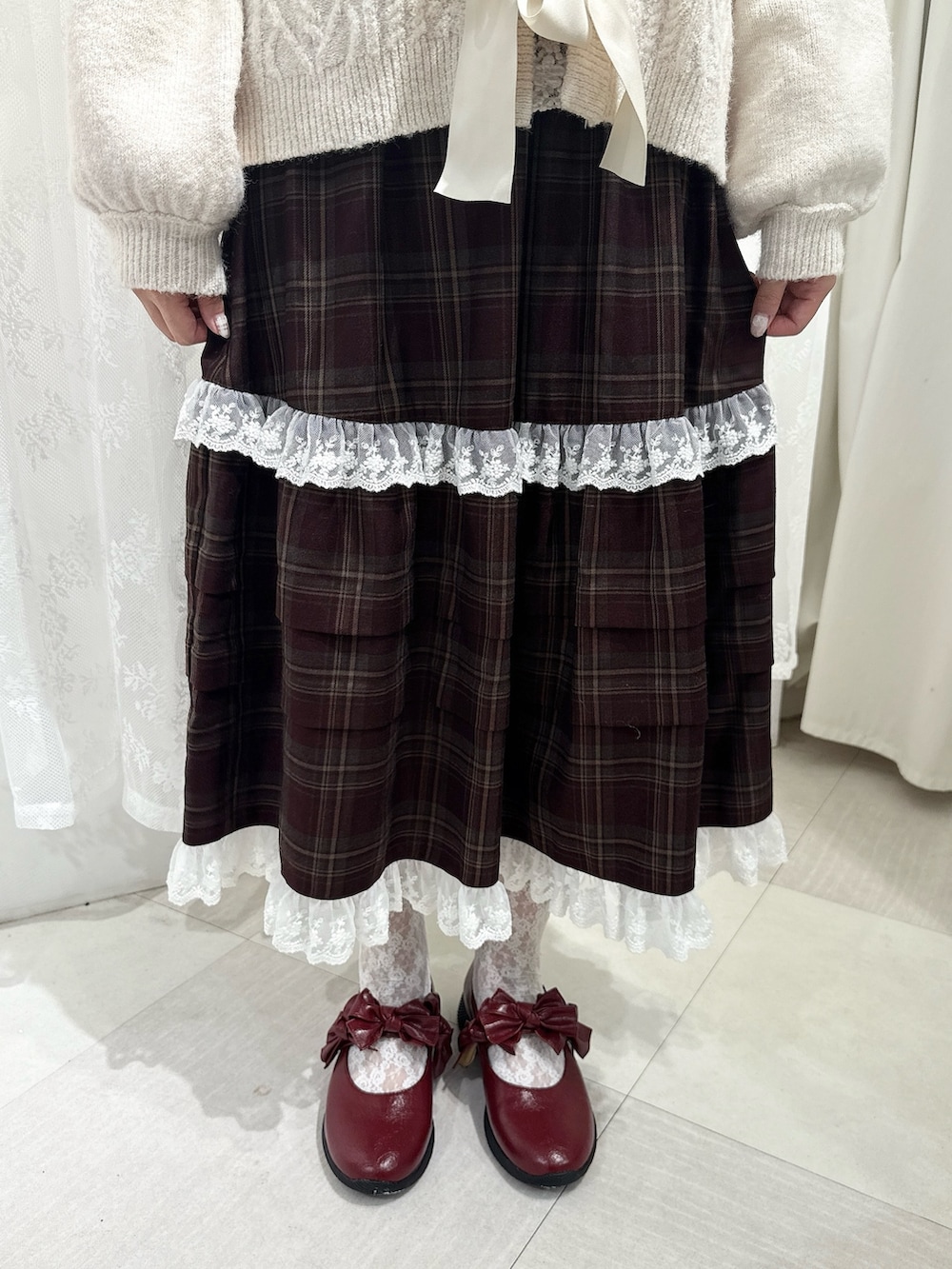 ホワイト系のカーディガン/ボレロ、ホワイト系のTシャツ/カットソー、ブラウン系のスカートを着用したレディースの夏コーディネートの6枚目の写真