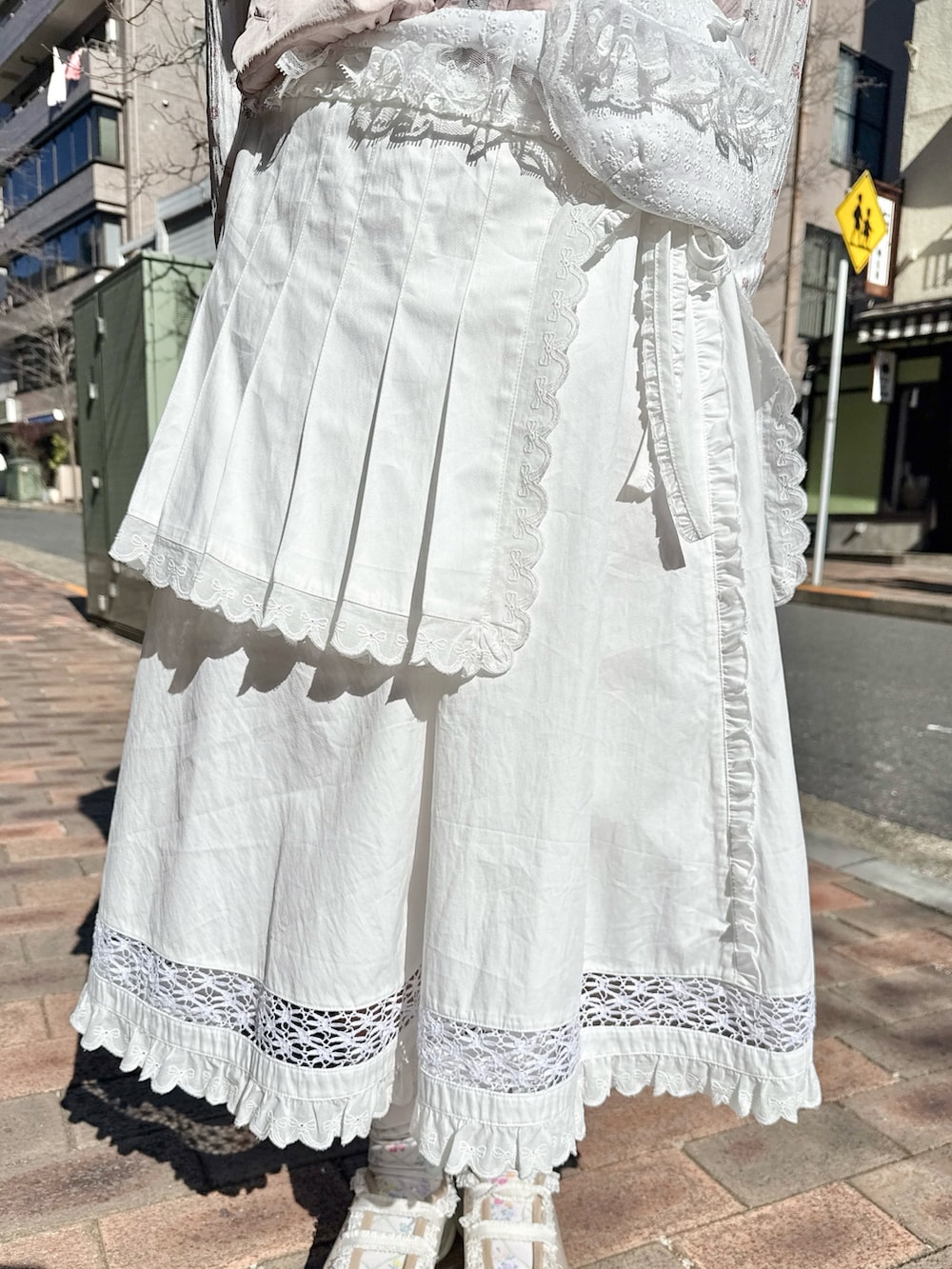 ピンク系のベスト、ピンク系のTシャツ/カットソー、ホワイト系のスカートを着用したレディースの春コーディネートの8枚目の写真