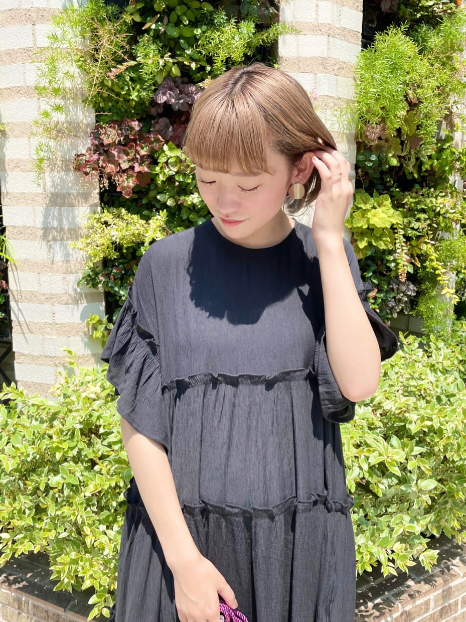 ブラック系のワンピース、レッド系のその他シューズ、パープル系のハンドバッグを着用したレディースの夏コーディネートの3枚目の写真