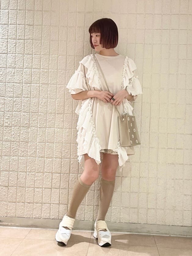 ホワイト系のチュニック、ホワイト系のその他パンツ、ゴールド系のショルダーバッグを着用したレディースの春コーディネートの2枚目の写真